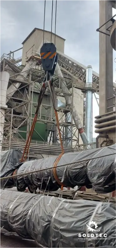 Foto do momento em que um colaborador da Soldtec está içando um cano durante um serviço de montagem na empresa Supremo Secil Cimentos.